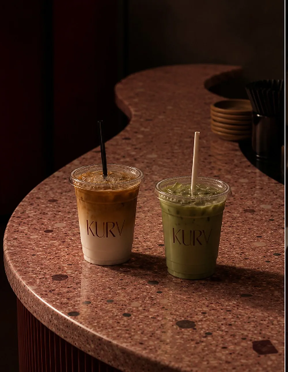 Un iced latte et un matcha KURV posés sur le comptoir en terrazzo