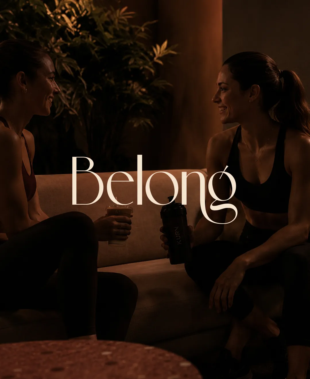Belong — two women talking in the lounge after class